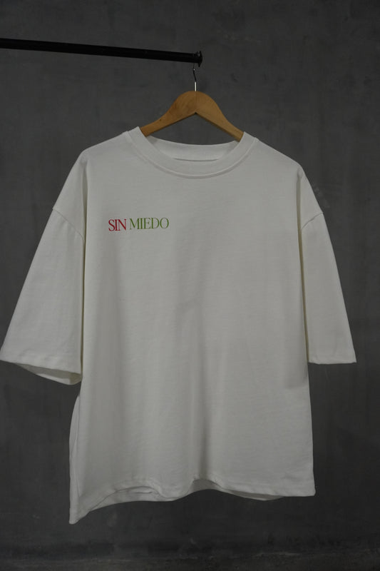 durable oversized crop fitted tee, white canvas with 'Sin Miedo' on the right side of chest in Mexico colors. back side has strawberry graphic in green red and black accents 